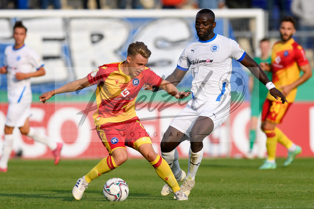 LOTKSC20210809_021 | Fussball, Herren: Christoph Kobald (Karlsruher SC) und Exauce Andzouana (Sportfreunde Lotte) im Zweikampf beim Spiel der 1. Runde im DFB-Pokal zwischen SF Lotte und Karlsruher SC im Stadion am Lotter Kreuz am 09.08.2021 in Lotte, Deutschland.DFB / DFL REGULATIONS PROHIBIT ANY USE OF PHOTOGRAPHS AS IMAGE SEQUENCES AND/OR QUASI-VIDEO. - Realisiert mit Pictrs.com