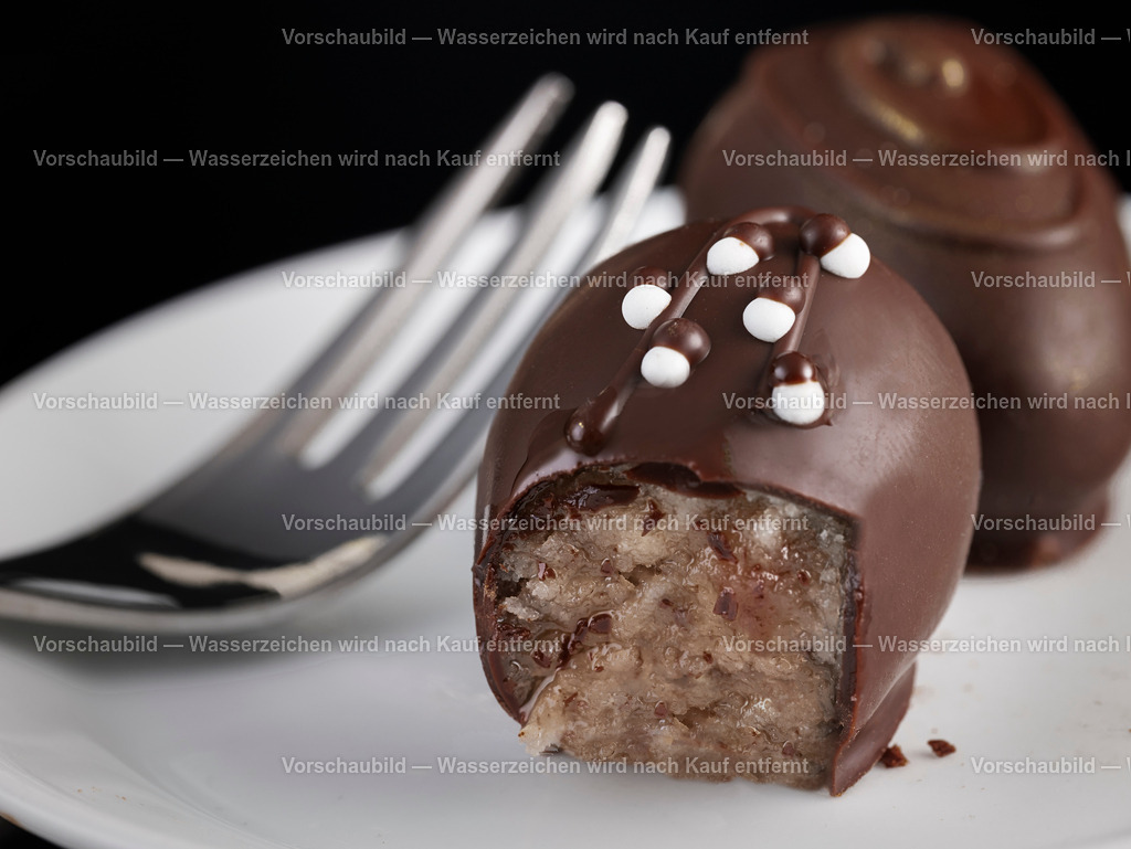 Makroaufnahme von zwei edlen und kunstvoll verzierten Marzipan Pralinen | Makroaufnahme von zwei edlen und kunstvoll verzierten Marzipan Pralinen. Auf einen porzelan teller mit Kuchengabel. - Realisiert mit Pictrs.com