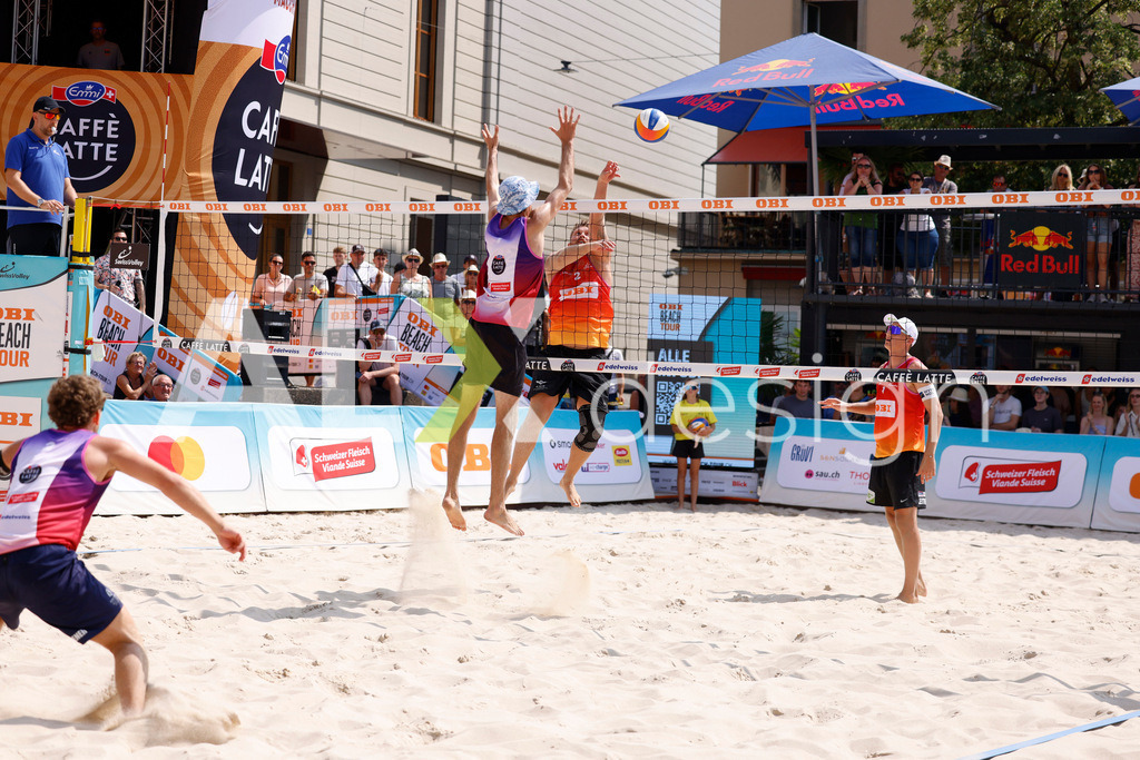 Obi BeachTour 2026 - Basel | BASEL, SWITZERLAND - JULY 19: MORITZ KINDL (AUT) attack / spike against SIMON HAGENBUCH (SUI) block  during the Obi BeachTour 2026 match between HAGENBUCH / HAUSSENER (SUI) and LEITNER / KINDL (AUT) at Barfüsserplatz on July 19, 2026 in Basel, Switzerland. - Realisiert mit Pictrs.com