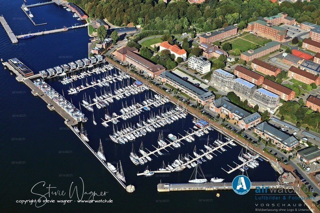 Die Marina Sonwik liegt am NE-lichen Stadtrand von Flensburg, an der SE-Küste der Flensburger Innenförde - Luftbild Marina Sonwik | Die Marina Sonwik liegt am NE-lichen Stadtrand von Flensburg, an der SE-Küste der Flensburger Innenförde, im ehemaligen Marinestützpunkt Flensburg-Mürwik. Sie ist eine moderne 5-Sterne-Marina mit 335 bis 360 Liegeplätzen und einer Wassertiefe von über fünf Metern, die auch Schiffe bis über 75 Fuß Länge problemlos aufnehmen kann. Die zum Teil noch aus der Kaiserzeit stammenden Marinegebäude stehen unter Denkmalschutz und dienen heute als Büro- und Gewerbeflächen sowie Eigentumswohnungen. Auf den Außenmolen befinden sich moderne Wasserhäuser, die teilweise privaten Bootsanlegern vorbehalten sind.