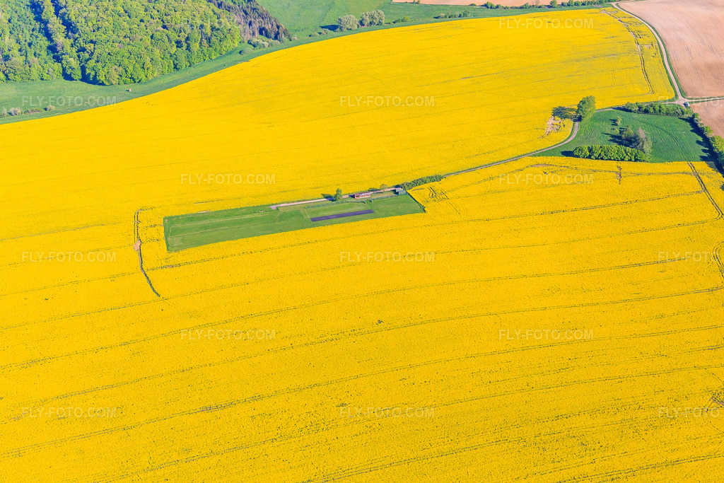 Aerial view: Model airfield in a blooming rapeseed field in Gros-Réderching in the state Moselle, France. – Photo: IMG_146091.jpg taken on 05/01/2025 by Werner Riehm/FLY-FOTO.com – Resolution of the original: 5472 x 3648 px