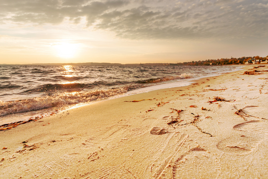 Wandbild: Sonnenaufgang am Strand in Eckernförde | Dieses Wandbild im Querformat zeigt einen schönen Sonnenaufgang am Strand ein Eckernförde. Der Himmel ist durch die morgendliche Sonne noch leicht rötlich.  - Realisiert mit Pictrs.com