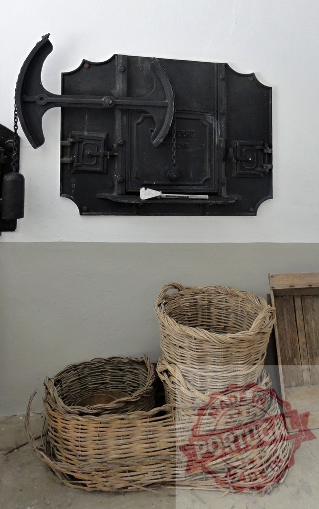 Rustic bread oven and traditional wicker baskets | Cast iron oven door with lever mechanism and handmade wicker baskets on the floor - Realisiert mit Pictrs.com