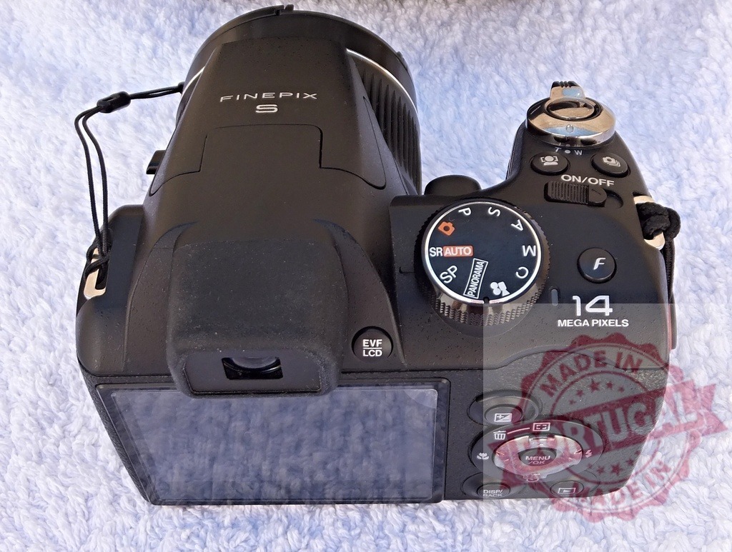 Fujifilm FinePix S bridge camera on white background | Black Fujifilm FinePix S digital camera displaying controls and screen from above - Realisiert mit Pictrs.com