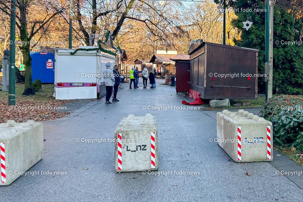 Linz_ Weihnachtsmarkt_ Terrorschutz_ 18.11.2025-6 | 18.11.2025, LINZ, AUT, Weihnachtsmarkt, im Bild Themenbild, Betonbarrieren, Betonblock, Terrorschutz, Volksgarten, Stadt, L_nz, Sicherheit, Fußgaengerzone, Weihnachtsmarkt, Huetten, Winter, Bauume ohne Laub, Absperrung, Verkehrsschutz, oeffentlicher Platz, Menschen, urban, Feature, Symbolbild