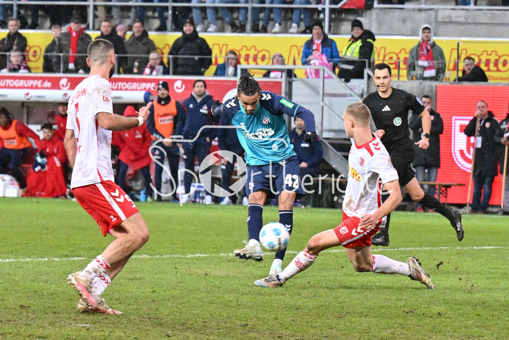 SSV Jahn Regensburg - 1. FC Köln | in dieser Szene verhindert blockt Louis BREUNING (SSV Jahn Regensburg 16) einen Schuss von Damion DOWNS (1. FC Koeln 42) / 2. Bundesliga: SSV Jahn Regensburg - 1. FC Koen, Jahnstadion am 08.12.2024