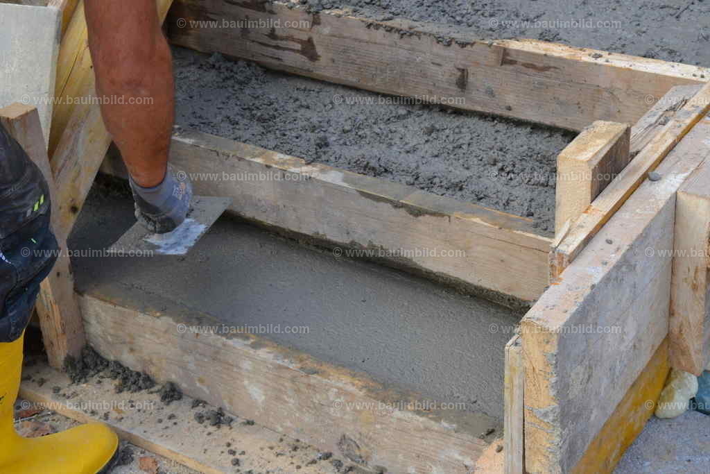 Betonstufen glätten | Arbeiter beim Glätten von betonierten Stufen