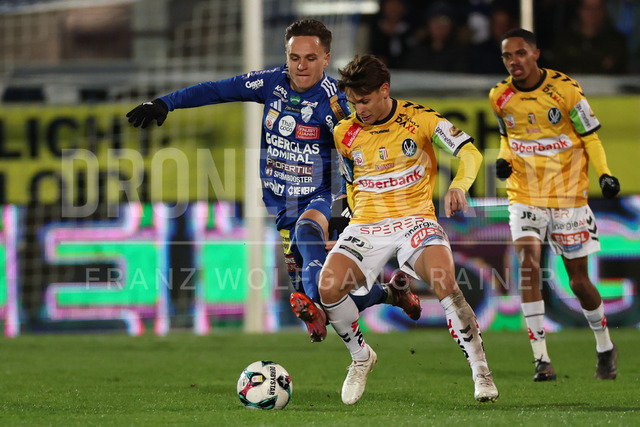 TSV Egger Glas Hartberg vs SV Oberbank Ried – Austrian Bundesliga Match | The image shows Lukas Fridrikas (Hartberg) and Jonas Mayer (Ried) fight for the ball, at the Bundesliga match TSV Hartberg vs SV Ried at Profertil Arena Hartberg. 22.11.2025