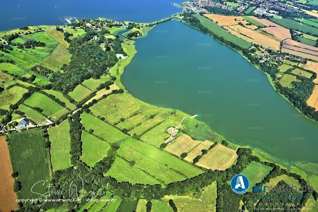 Haithabu - Warenhandel über die Schlei - Luftbild | Über die Schlei wurden in Haithabu Pelze, Sklaven, Eisen, Waffen, Glasperlen, Stoffe, Bernstein, Fisch, Getreide und Luxusgüter wie Seide und Gewürze aus dem Nahen Osten und Byzanz transportiert.