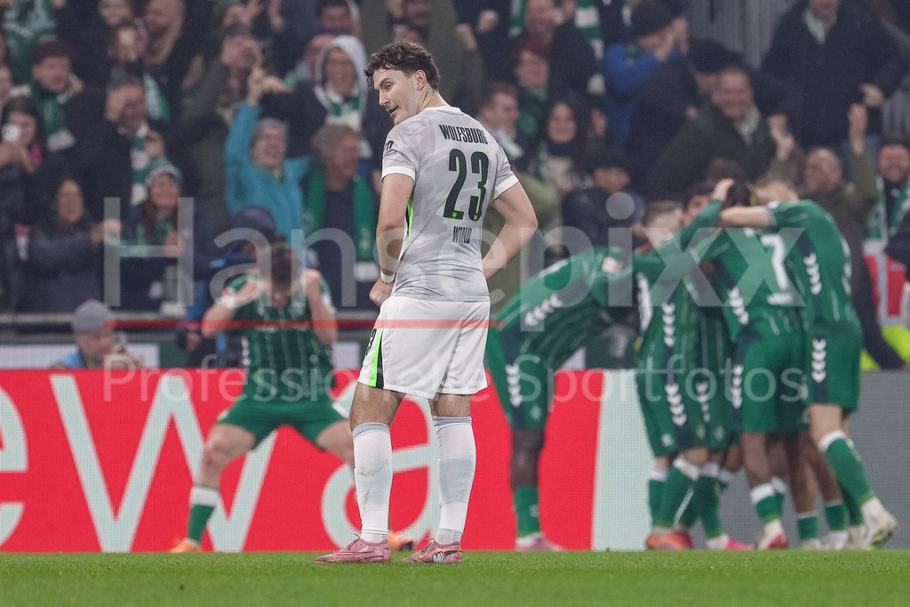Fussball, Bundesliga, SV Werder Bremen - VfL Wolfsburg | Jonas Wind (VfL Wolfsburg, 23) enttäuscht schauend, Enttäuschung. im Hintergund die Spieler des SV Werder Bremen mit Torjubel, Jubel, jubeln, jubelt, optimistisch, Spielszene, Highlight, Freude über das Tor zum 2:1, DIE DFL-RICHTLINIEN UNTERSAGEN JEGLICHE NUTZUNG VON FOTOS ALS SEQUENZBILDER UND/ODER VIDEOÄHNLICHE FOTOSTRECKEN. DFL REGULATIONS PROHIBIT ANY USE OF PHOTOGRAPHS AS IMAGE SEQUENCES AND/OR QUASI-VIDEO.