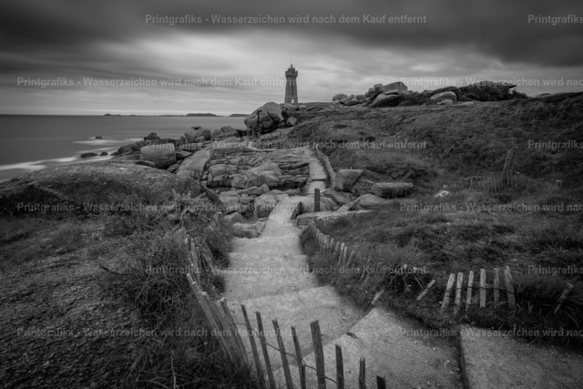 Leuchtturmpfad in Schwarzweiß | Monochrome Küstenlandschaft in der Bretagne mit einem schmalen Pfad, der durch Felsen und Gras zum Leuchtturm führt. Die Schwarzweißwirkung, der dunkle Himmel und die raue Küste verleihen der Szene eine stille, zeitlose und maritime Stimmung. - Realisiert mit Pictrs.com