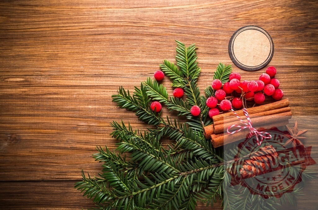 Christmas decoration on wooden table is creating festive atmosphere | Christmas decoration on wooden table with cinnamon sticks, berries and pine cone - Realized with Pictrs.com