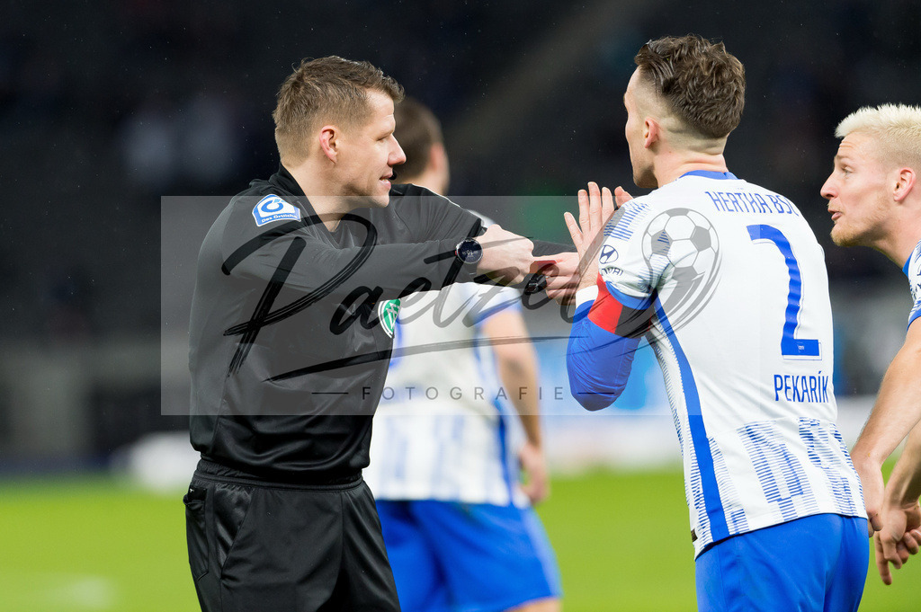 BSCRBL20220220_222 | Fussball, Herren: Schiedsrichter Patrick Ittrich und Peter Pekarik (Hertha BSC) diskutieren bei dem Spiel der 1. Bundesliga zwischen Hertha BSC und RB Leipzig im Olypiastadion am 20.02.2022 in Berlin, Deutschland.DFB / DFL REGULATIONS PROHIBIT ANY USE OF PHOTOGRAPHS AS IMAGE SEQUENCES AND/OR QUASI-VIDEO. - Realisiert mit Pictrs.com