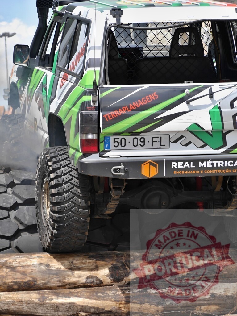 4x4 vehicle climbing logs during an off-road race competition | Off-road vehicle climbing over logs during an off-road race competition - Realized with Pictrs.com