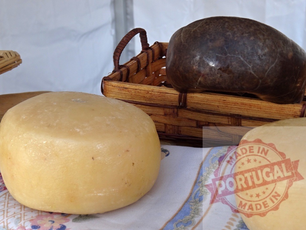 Traditional cheese and sausage products on rustic table | Artisan cheese and dark sausage on a patterned cloth, offering rustic farm food - Realized with Pictrs.com