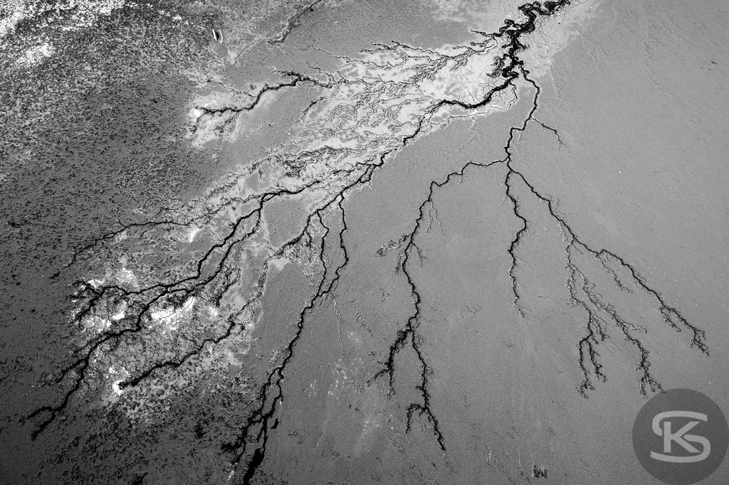 Ground Levels – Abstrakte Landschaften entwässerter Seen aus der Vogelperspektive | Ground Levels zeigt Drohnenaufnahmen entwässerter Seegründe, die zwischen Realität und Abstraktion oszillieren. Rinnsale, Pfützen und Muster verwandeln sich aus der Luft zu abstrakten Kompositionen – Fotokunst von Stefan Kuhn. - Realisiert mit Pictrs.com