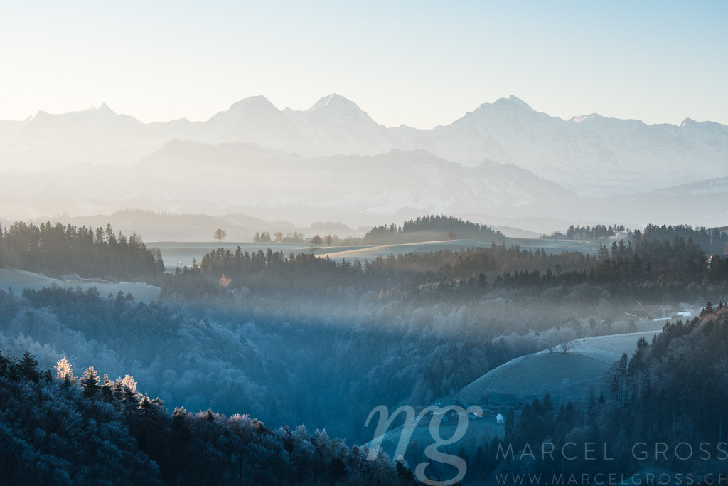Eiger Mönch and Jungfrau and the hills of Emmental on a winter morning | Die ideale Geschenkidee für Naturliebhaber. Naturbilder von Marcel Gross Photography für ihr Zuhause in den verschiedensten Formaten und Materialien. - Realisiert mit Pictrs.com
