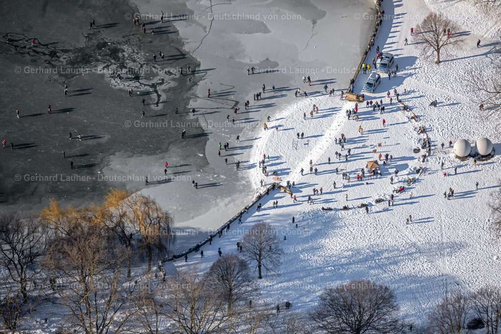 4043957 | MüNSTER 13.02.2021 Winterlich schneebedeckte Spaziergänger und Passanten laufen auf der Eisschicht der zugefrorenen Uferbereiche der See - Oberfläche des Aasee im Ortsteil Pluggendorf in Münster im Bundesland Nordrhein-Westfalen, Deutschland. // Wintry snowy strollers and passers-by walk on the ice sheet of the frozen bank areas of the lake - surface of Aasee in the district Pluggendorf in Muenster in the state North Rhine-Westphalia, Germany. Foto: Gerhard Launer