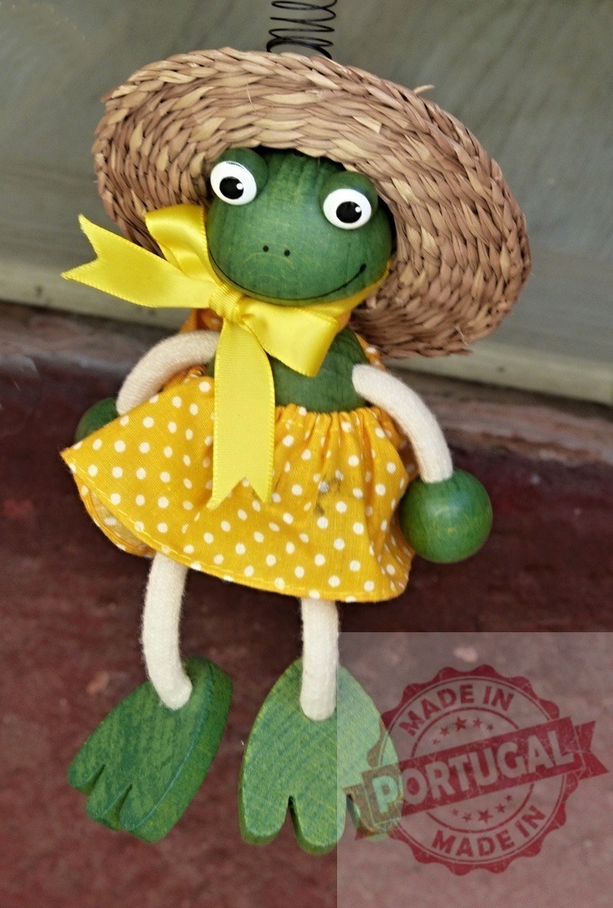 Cute frog figurine wearing yellow polka dot dress and straw hat | Frog figurine with a straw hat and yellow polka dot dress, hanging on a spring - Realized with Pictrs.com