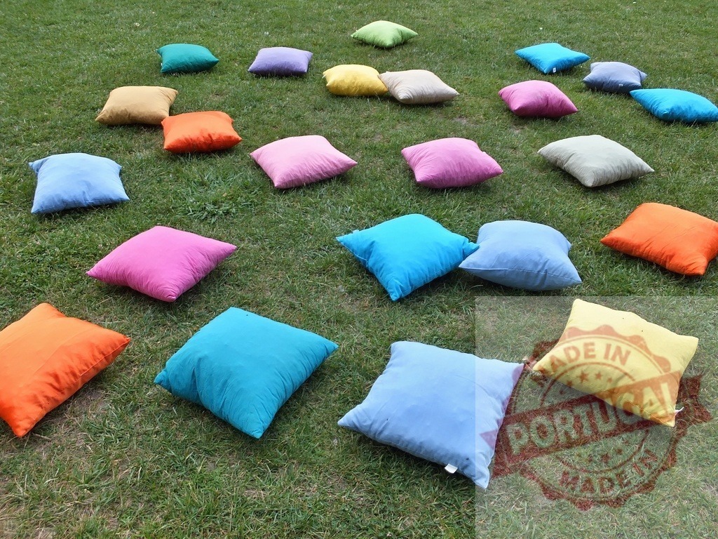 Colorful cushions scattered on green grass for outdoor relaxation | Colorful cushions scatter on green grass, inviting comfort and relaxation outdoors - Realized with Pictrs.com