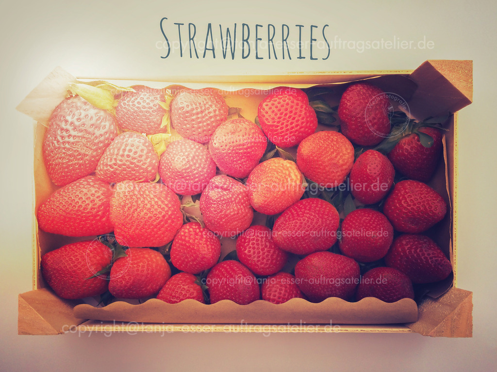 Strawberries | Erdbeer Ernte in einer Holzkiste. Frische Beerenfrüchte von oben fotografiert in einem Vintage Look mit englischem Text: Erdbeeren. 