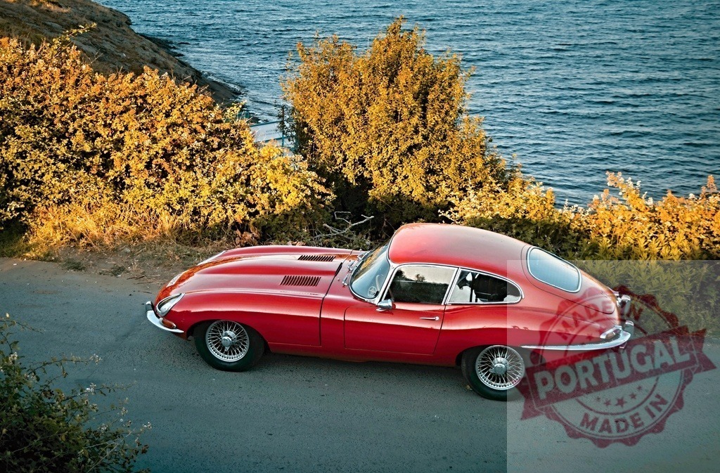 Red Jaguar E-Type parked seaside coastal road | Red Jaguar E-Type classic car parked on a scenic coastal road above the sparkling sea - Realized with Pictrs.com