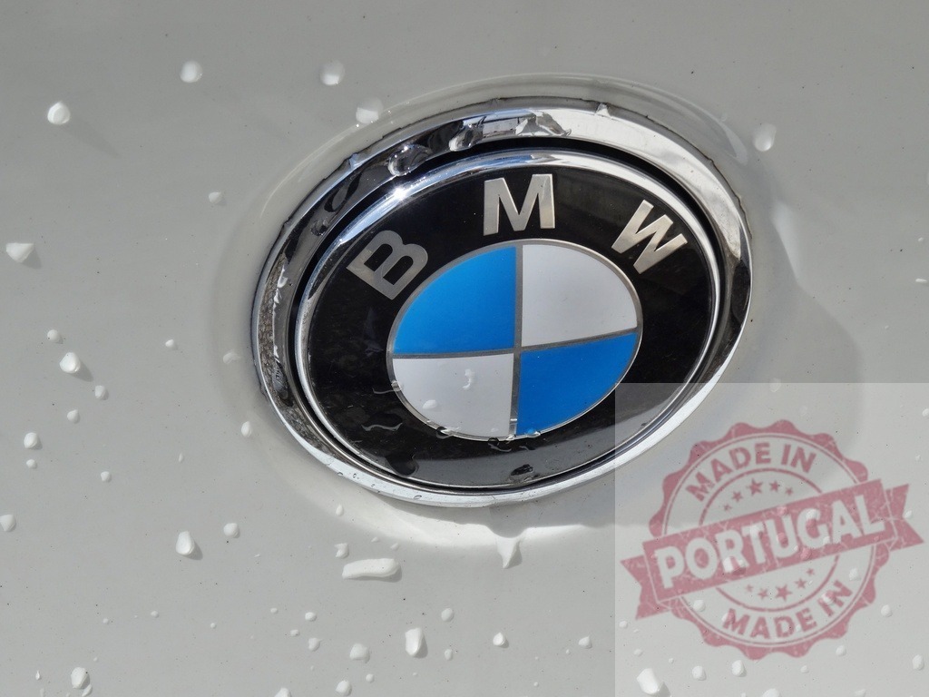 BMW emblem shows on a white car with water drops | BMW logo on white car surface with water droplets - Realized with Pictrs.com