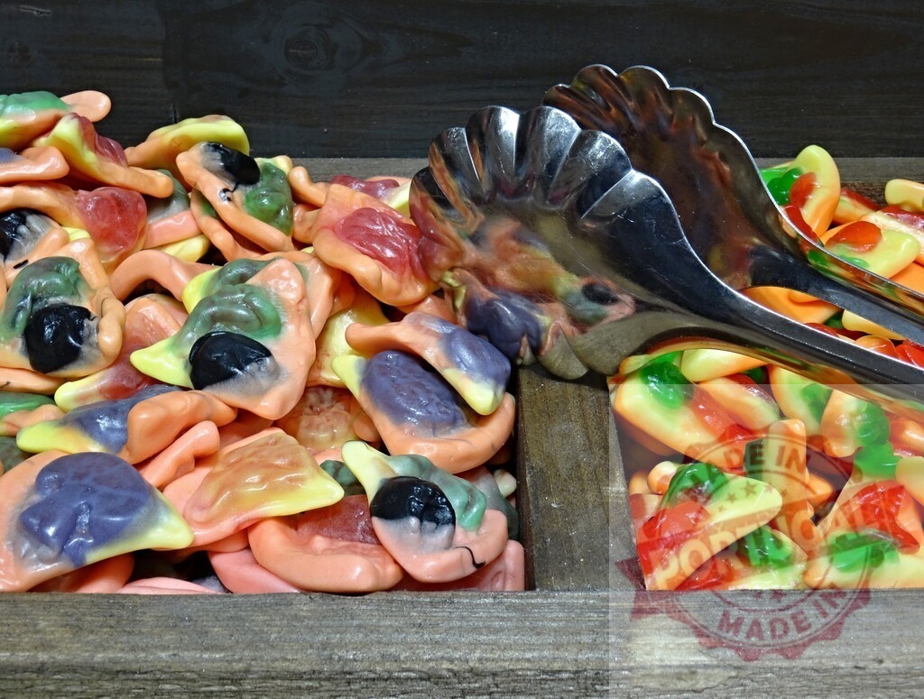 Bulk gummy candies in wooden bin with tongs | Colorful gummy candies with tongs in a pick and mix display, offering a sweet treat - Realized with Pictrs.com