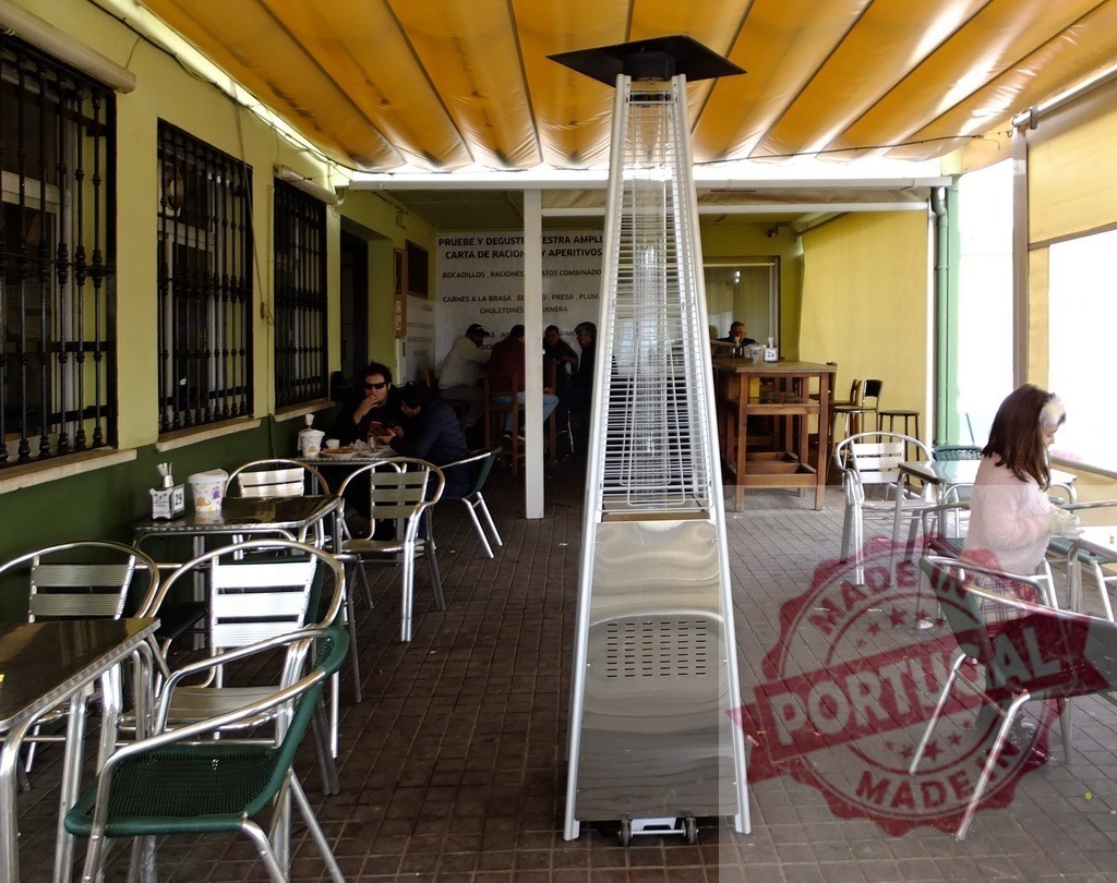 Outdoor restaurant patio with heater and customers dining | Customers enjoying a meal outdoors on a restaurant terrace with a patio heater and canopy - Realisiert mit Pictrs.com