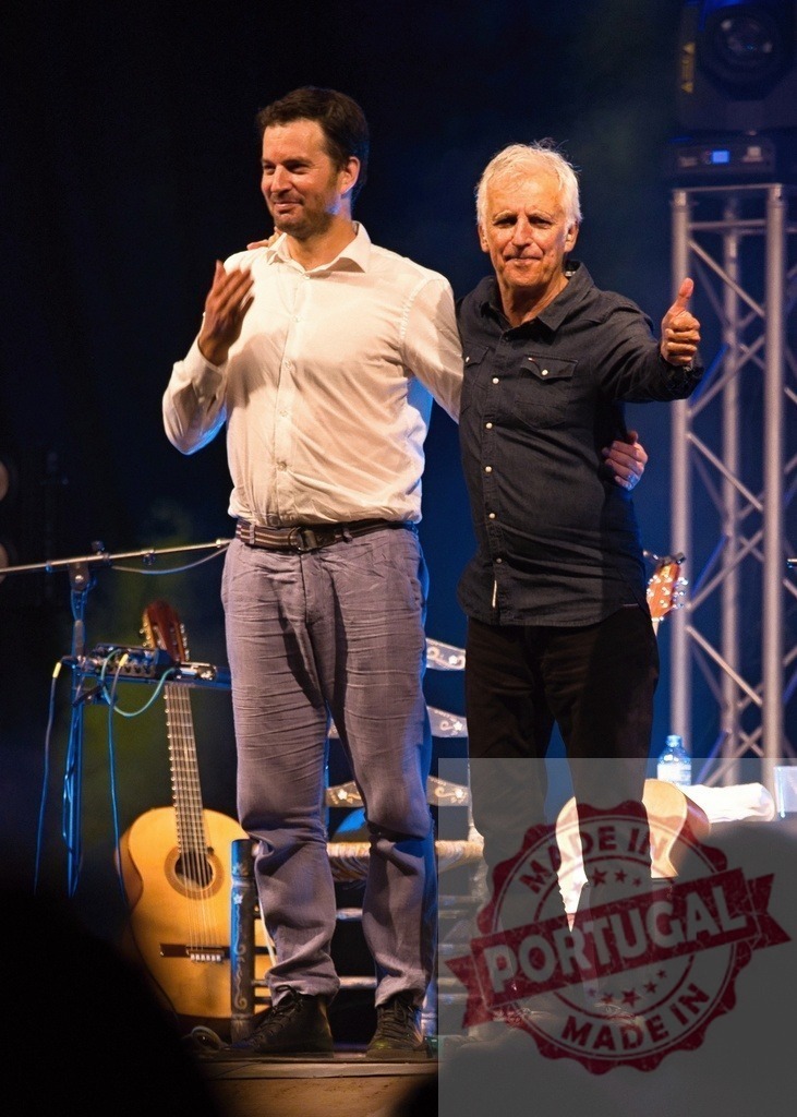 Thomas Kahn and Philippe Lavil performing on stage | Thomas Kahn and Philippe Lavil standing together on stage after a concert with guitars - Realized with Pictrs.com