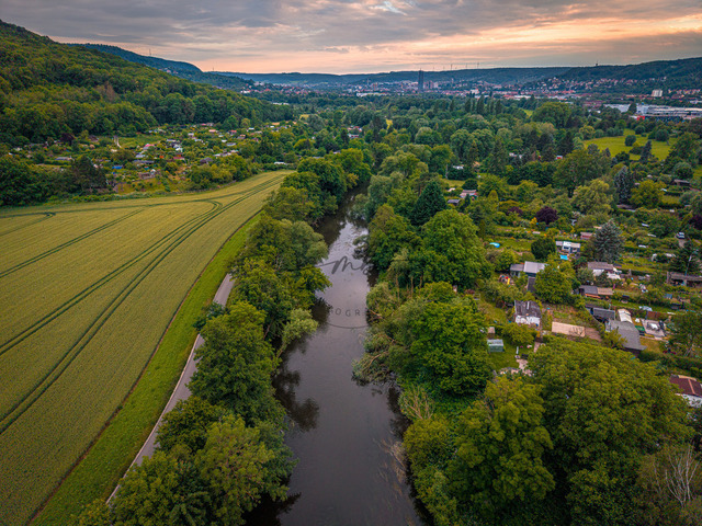 2026-06-17_20-49-15_000 | Blick auf gewundene Flusslandschaft, umgeben von üppigen Bäumen und kleinteiligen Feldern bei untergehender Sonne, Jena, Thüringen, Deutschland - Realisiert mit Pictrs.com