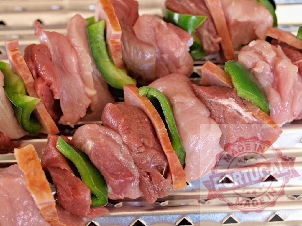 Uncooked meat kebabs with peppers on barbecue grill | Uncooked meat kebabs with pork, beef, and green bell peppers on a metal grill - Realized with Pictrs.com