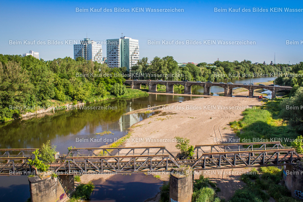 Luftbilder Magdeburg-2490 | Die Anna-Ebert-Brücke und die unmittelbar benachbarte Eisenbahnbrücke der ehemaligen Kanonenbahn gehören zu den eindrucksvollsten Brückenensembles Magdeburgs. Während die historische Eisenbahnbrücke an die strategisch bedeutende Bahnverbindung des 19. Jahrhunderts erinnert, verbindet die Anna-Ebert-Brücke heute die Altstadt mit dem Stadtpark Rotehorn und ist eine wichtige Fuß- und Radwegverbindung über die Alte Elbe. Gemeinsam erzählen beide Bauwerke ein Stück Magdeburger Verkehrs- und Stadtgeschichte.Die Aufnahme entstand aus einer tiefen Drohnenperspektive und rückt beide Brücken in den Mittelpunkt der Komposition. Im Vordergrund treten die weitläufigen Sandbänke der Alten Elbe deutlich hervor und verleihen dem Bild eine außergewöhnliche Struktur. Die ruhigen Wasserflächen, die filigranen Brückenkonstruktionen und die niedrige Flughöhe erzeugen eine spannende räumliche Wirkung, bei der sich Natur und Ingenieurbau harmonisch ergänzen.Die Fotografie zeigt eindrucksvoll den reizvollen Kontrast zwischen historischer Eisenbahninfrastruktur und moderner Fußgängerbrücke. Die natürlichen Sandbänke der Alten Elbe bilden dabei einen ungewöhnlichen Vordergrund und unterstreichen den landschaftlichen Charakter dieses Elbabschnitts. So entsteht ein Panorama, das die Vielfalt der Magdeburger Brückenlandschaft ebenso eindrucksvoll dokumentiert wie die enge Verbindung von Technik, Wasser und Natur. - Realisiert mit Pictrs.com
