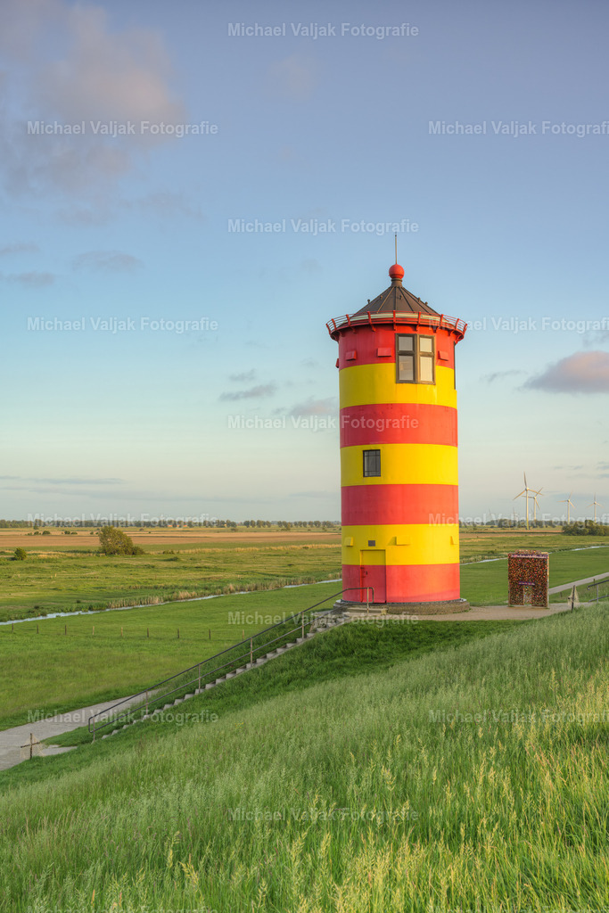 Pilsumer Leuchtturm in Ostfriesland | Blick vom Deich zum Pilsumer Leuchtturm. Der Leuchtturm ist ein Wahrzeichen Ostfrieslands und vor allem aus dem Film "Otto - der Außerfriesische" bekannt. Er ist dadurch einer der bekanntesten Leuchttürme Deutschlands.Der Turm weist eine leichte Schieflage nach Osten auf (im Bild links). Im Laufe der Jahrzehnte hat er sich durch den oft starken Wind in diese Schräglage begeben, da das Fundament selbst nicht auf Stützen steht. Es handelt sich hierbei also nicht um einen Bildfehler. - Realisiert mit Pictrs.com