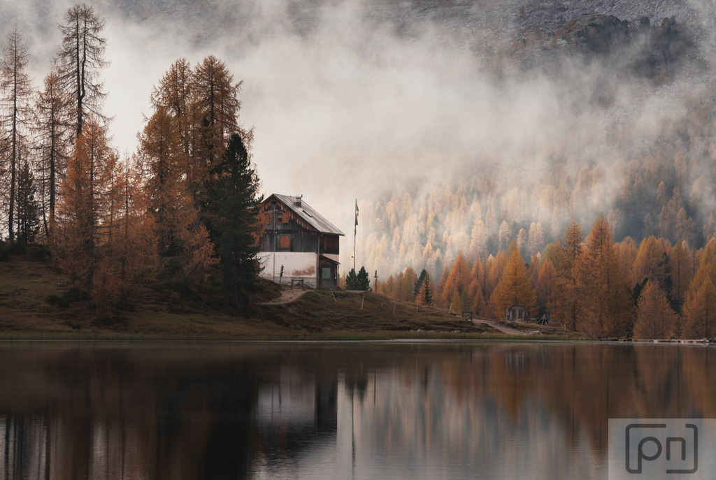 Federasee | Wenn der Nebel über den Lago Federa in den Herbstmorgen einzieht, entsteht eine mystische und faszinierende Szenerie. Der dichte Nebel hüllt die umliegenden Bäume und Berge in einen sanften Schleier, der die Konturen verschwimmen lässt und eine geheimnisvolle Atmosphäre schafft. Das diffuse Licht verleiht der Landschaft eine weiche und verträumte Stimmung, während die Umrisse der Bäume und des Sees im Nebel verschwimmen, was eine einzigartige und malerische Kulisse für Fotografen schafft. Dieser flüchtige Moment des Nebels verleiht den Aufnahmen eine magische Note und kann zu äußerst fesselnden Bildern führen.