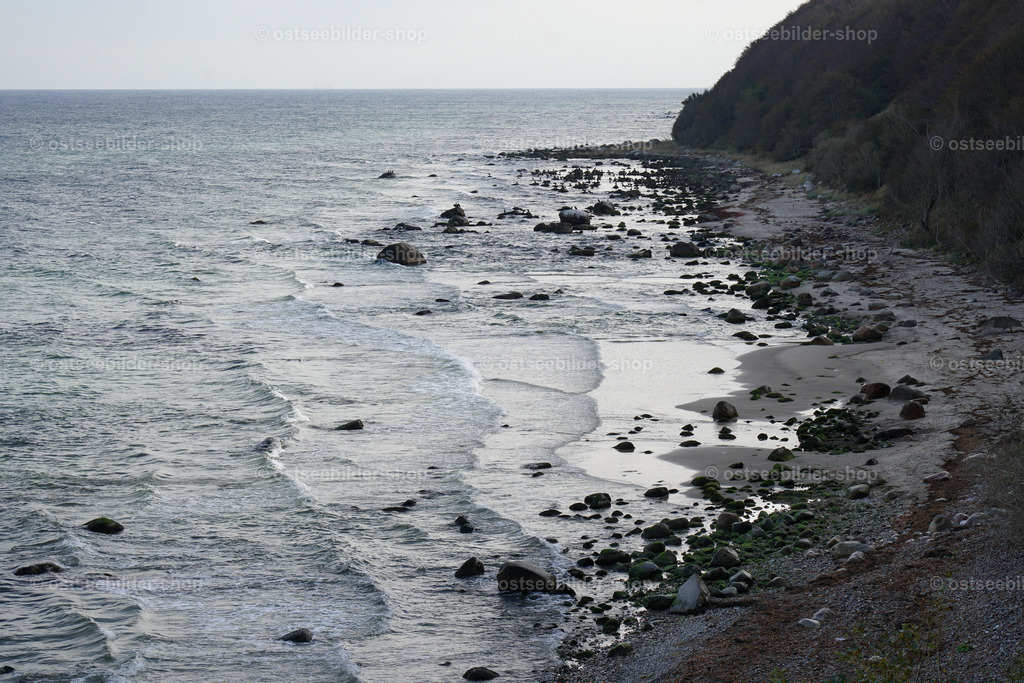 Steinestrand im Schatten des Kliffs | Im Schatten des Kliffs reflektiert das Ostseewasser das Licht des Himmels und erzeugt dadurch einen kräftigen Kontrast zwischen Dunkel und Hell.