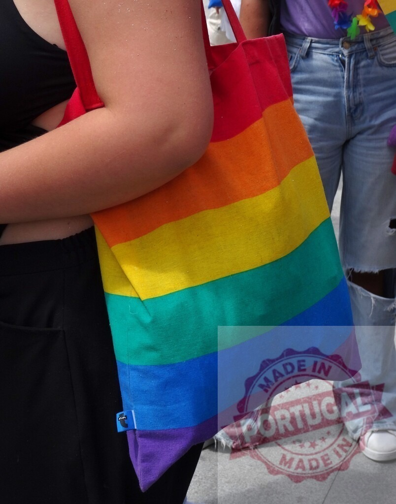 Person carrying rainbow pride tote bag showing support | Person carrying a rainbow colored tote bag, celebrating LGBTQ+ pride and community - Realisiert mit Pictrs.com