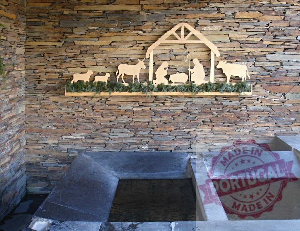 Wooden nativity scene hanging on a stone wall above a wash house | Christmas decoration representing the nativity scene with Jesus, Mary and Joseph, hanging on a stone wall above a wash house - Realized with Pictrs.com