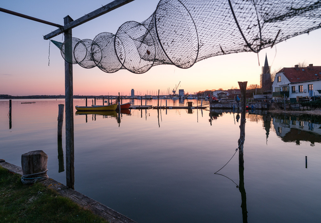 zeitenwende-farbe-01-14 | Letztes Abendlicht setzt Boote, Brücken und die Netze der Fischer auf dem Holm in Schleswig an der Schlei in Szene. - Realisiert mit Pictrs.com