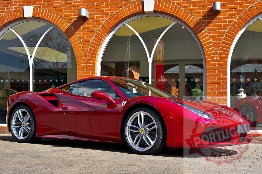 Shiny red Ferrari 488 GTB parked in front of a dealership | Red Ferrari 488 GTB parked outside a Ferrari dealership on a sunny day - Realized with Pictrs.com