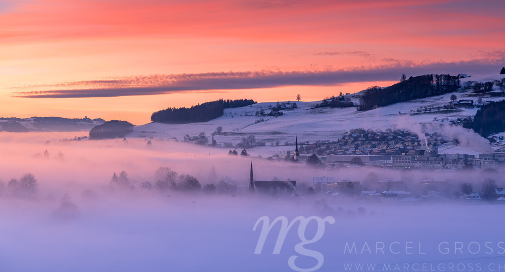 Kitschiger Wintersonnenuntergang über Konolfingen mit Blick aufs Nebelmeer | Die ideale Geschenkidee für Naturliebhaber. Naturbilder von Marcel Gross Photography für ihr Zuhause in den verschiedensten Formaten und Materialien. - Realisiert mit Pictrs.com