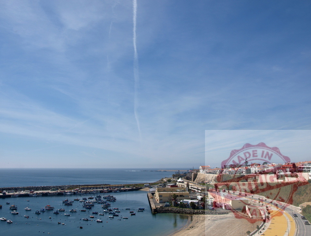 Ericeira fishing village harbor with boats and ocean | Ericeira's fishing port featuring many boats, ocean, and coastal town on a sunny day - Realized with Pictrs.com