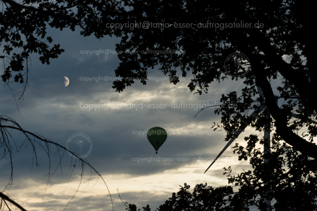 145 Ballon 3 | Ein Heißluftballon schwebt in den bewölkten Himmel. Es ist Abend. Im Vordergrund sind Äste als Silhouetten zu erkennen. Der Mond scheint.