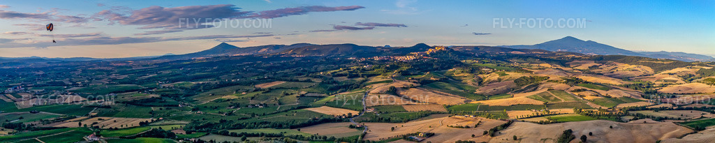 Aerial view: Panorama - Perspective with paraglider of the peaks in the rocky and mountainous landscape in Montepulciano in the state Siena, Italy.Photo: IMG_43353-Bearbeitet.jpg taken on 07/25/2011 by Werner Riehm/FLY-FOTO.comResolution of the original: 12106 x 2418 px