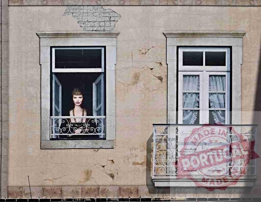 Trompe l'oeil mural of woman in window Lisbon | Street art mural creating an optical illusion of a woman looking from a building window - Realized with Pictrs.com