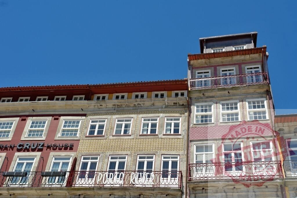 Colorful building facades lining the Douro River in historic Ribeira | Traditional architecture facades in Ribeira neighborhood Porto Portugal - Realized with Pictrs.com