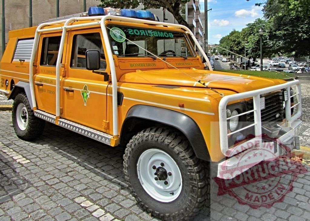Yellow Bombeiros Land Rover Defender emergency vehicle in Santo Tirso | Bombeiros Santo Tirso Land Rover Defender parked on a cobblestone street - Realisiert mit Pictrs.com
