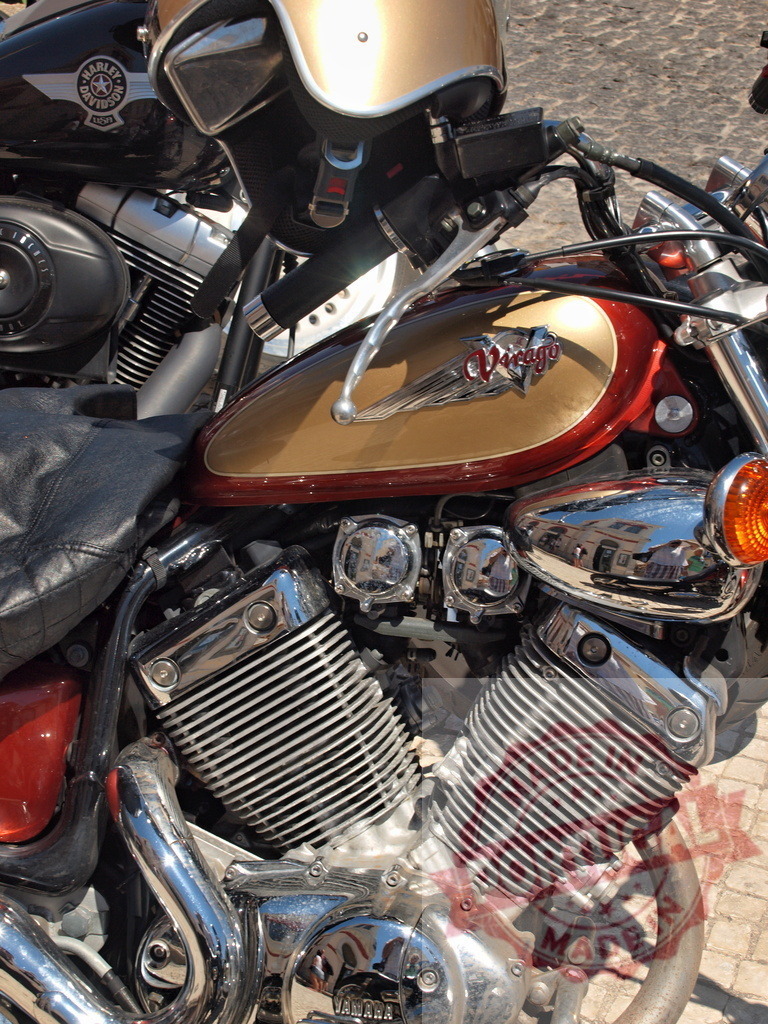 Yamaha Virago motorcycle engine with chrome details | Yamaha Virago cruiser motorcycle engine, fuel tank, and handlebars with a helmet resting on top - Realized with Pictrs.com