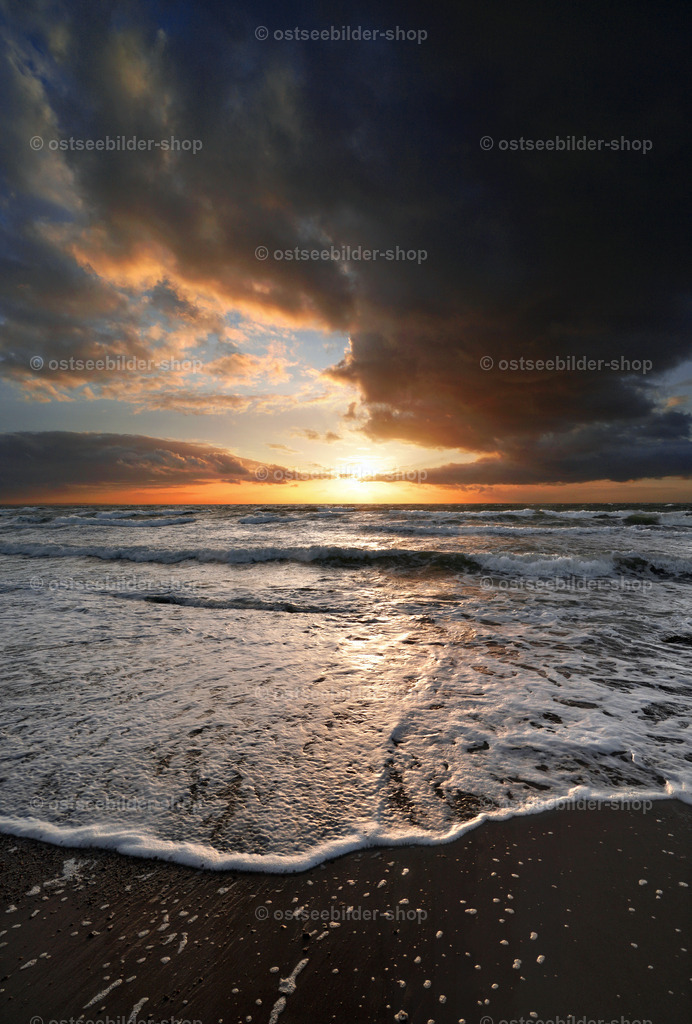 Auslaufende Ostseewellen im Licht der untergehenden Abendsonne | Wellen laufen langsam auf dem glatten Sand des Strandes aus. Am Horizont beginnt ein abendliches Schauspiel.