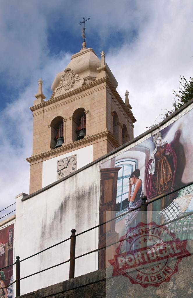 Church bell tower with historical street mural | Church bell tower standing beside a street wall painted with a religious mural - Realisiert mit Pictrs.com